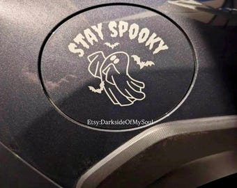 May include: A black, circular decal with the words "STAY SPOOKY" in white, along with a ghost and bats. The decal is affixed to a dark gray surface. Etsy: DarksideOfMySoul is printed at the bottom.