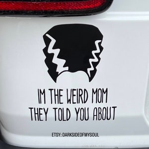 May include: A white car with a black and white sticker that says "I'm the weird mom they told you about" and "Etsy: Darksideofmysoul".