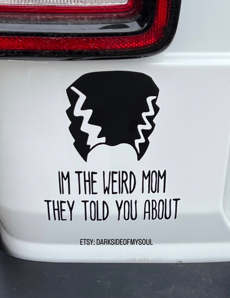 May include: A white car with a black and white sticker that says "I'm the weird mom they told you about" and "Etsy: Darksideofmysoul".