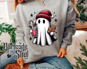 May include: A gray sweatshirt with a white ghost wearing a red Santa hat holding a gingerbread man and a red drink. The ghost is surrounded by stars. The text "Darkside of my Soul.com" is printed on the bottom of the sweatshirt.