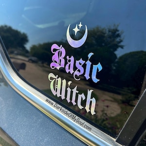 May include: A car window with a holographic sticker that says "Basic Witch" in a gothic font with a crescent moon and stars above the text. The website www.DarksideOfMySoul.com is printed below the text.
