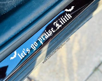 May include: Black and glossy car door sill protector with white text that reads "let's go praise Lilith" and bat silhouettes. The website address www.DarksideOfMySoul.com is also visible.