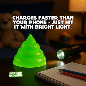 Rechargeable glow in the dark poop toy beside flashlight on nightstand, funny kids night light