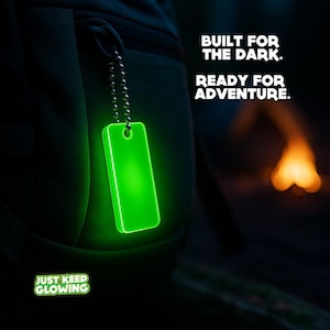 Glow in the dark keychain on camping backpack – rugged outdoor survival gear ready for adventure.