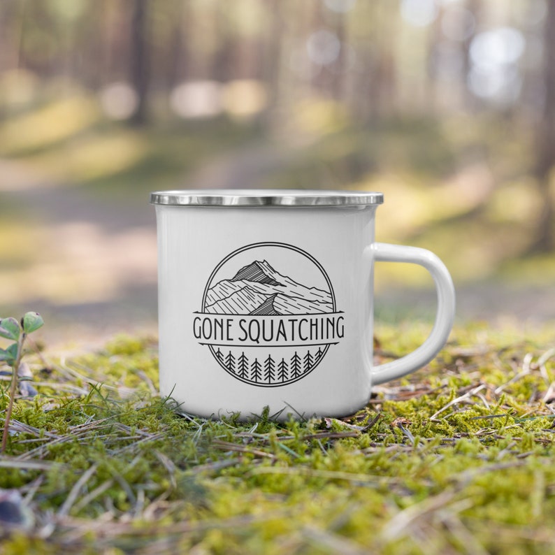 May include: White enamel camping mug with a black and white graphic of a mountain range and the text "Gone Squatching".