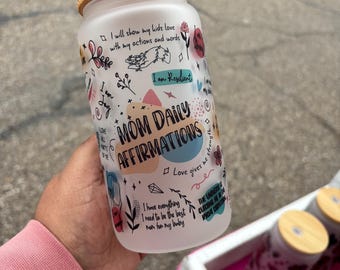 May include: A white frosted glass jar with a bamboo lid. The jar has a variety of colorful doodles and text, including "Mom Daily Affirmations" and "Love gives me the strength".