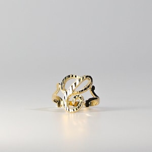 May include: A gold ring with a stylized letter 'L' design.