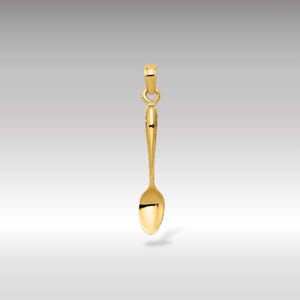 Può includere: Un ciondolo a forma di cucchiaio d'oro. Il cucchiaio ha una ciotola arrotondata e un manico dettagliato.