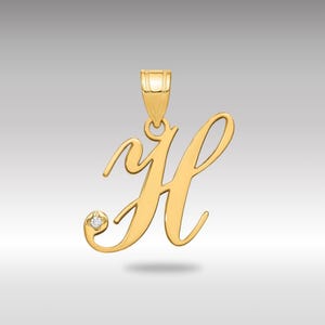 Puede incluir: Colgante dorado con forma de la letra "H" con un pequeño acento de diamante. El colgante tiene un lazo en la parte superior para una cadena. El diseño es de estilo cursiva.