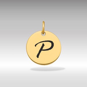 Pode incluir: Um pingente redondo dourado com a letra "P" em fonte cursiva preta. O pingente tem uma pequena argola na parte superior para uma corrente. O fundo é um gradiente cinza claro.