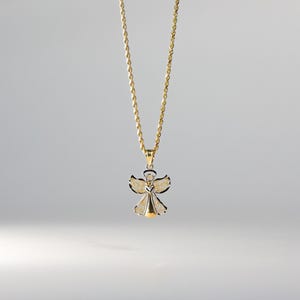 May include: A gold chain necklace with a two-tone angel pendant. The angel is made of silver with gold accents.