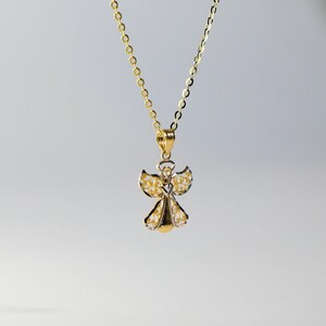 May include: A gold and silver angel pendant necklace. The angel has delicate wings and a heart in the center of its chest.
