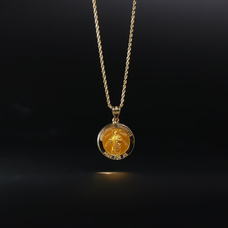 May include: A gold chain necklace with a round pendant featuring a religious image of Saint Jude Thaddeus. The pendant has the words "Saint Jude Thaddeus" and "Pray for Us" inscribed on it.