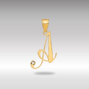 Puede incluir: Colgante dorado con forma de la letra "A". El colgante tiene un pequeño diamante en la parte inferior de la letra. El colgante está suspendido de una fianza dorada.