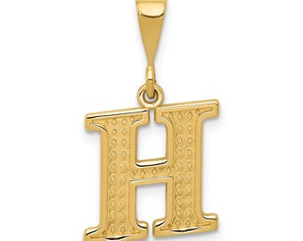 May include: A gold-colored pendant in the shape of the letter "H". The pendant has a textured surface with a diamond pattern. It includes a loop for attaching to a chain.