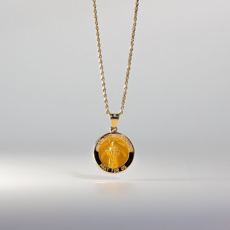 May include: A gold chain necklace with a round pendant featuring a depiction of Saint Jude Thaddeus. The pendant has the words "St. Jude Thaddeus" and "Pray for Us" inscribed on it.