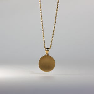 May include: A gold chain necklace with a round, brushed gold pendant.