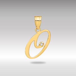 Pode incluir: Pingente dourado em forma da letra "O", com um pequeno diamante. O pingente tem um acabamento polido e uma argola na parte superior para uma corrente. O design é elegante e simples.