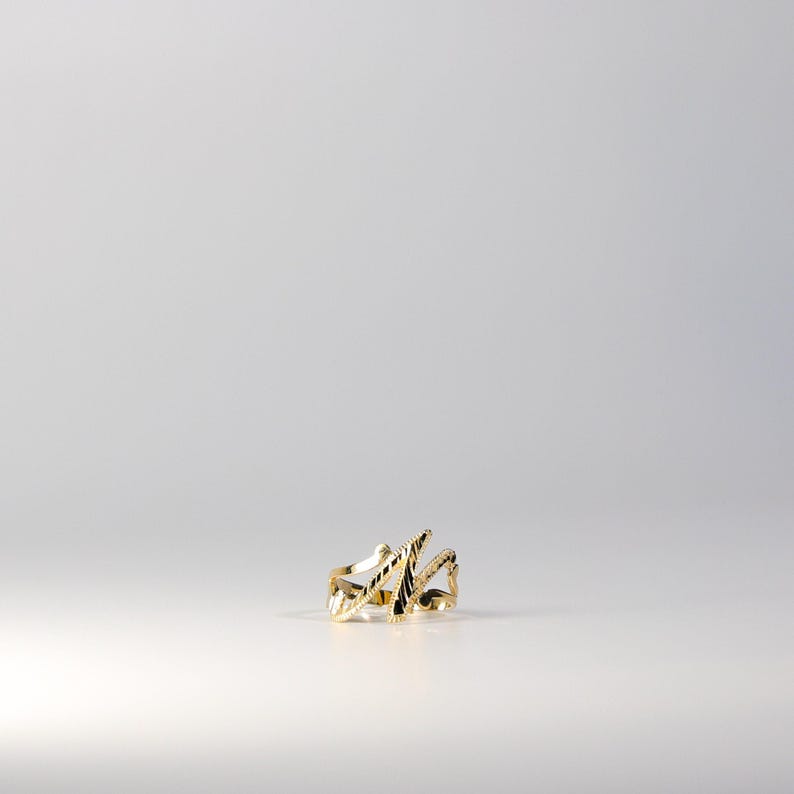 May include: A gold ring with a unique, abstract design. The ring is made of a smooth, shiny metal and has a textured surface.