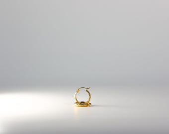 May include: A gold hoop earring with a textured surface.