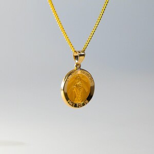 May include: A gold chain necklace with a round pendant featuring a depiction of Saint Jude Thaddeus. The pendant has the words "St. Jude Thaddeus" and "Pray for Us" inscribed around the image.