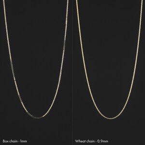 May include: Two gold chains on a black background. The chain on the left is a box chain, 1 mm thick. The chain on the right is a wheat chain, 0.9 mm thick.