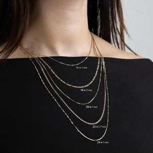 May include: Five gold chains of different lengths and widths, layered on a model's neck. The chains are labeled with their length and width in inches and millimeters: 16 in 1 mm, 18 in 2 mm, 20 in 1 mm, 22 in 1.7 mm, and 24 in 1 mm.