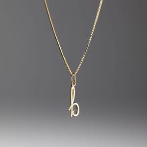 Peut inclure: Un collier en chaîne dorée avec un pendentif en forme de lettre 'b' cursive.
