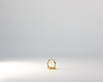 May include: A gold hoop earring with a simple design.