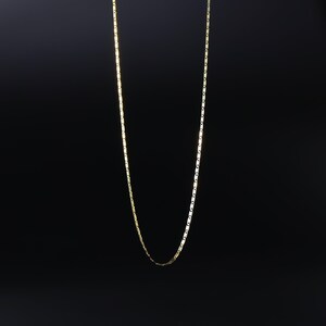 May include: A gold chain necklace with a box chain design.