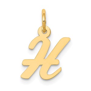 Puede incluir: Un colgante dorado con la forma de la letra "H" en escritura cursiva. El colgante tiene un lazo en la parte superior para sujetarlo a una cadena. La letra es lisa y brillante, con bordes redondeados.