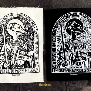 May include: Two fabric patches with a religious design. One is white, the other black. Both feature a greyhound-like figure with a halo, holding a staff and book. Text includes "PAX VOBIS" and "I BIND UNTO MYSELF TODAY".