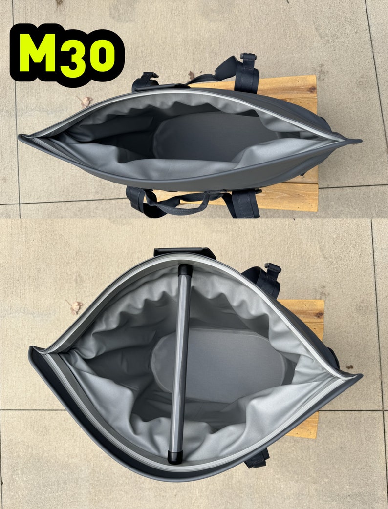 Puede incluir: Una bolsa de enfriador gris con cremallera, asa y correas negras. La bolsa est&aacute; abierta y el interior est&aacute; forrado con un material gris. La bolsa est&aacute; sobre una superficie de madera.