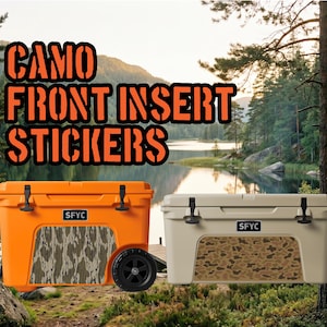 May include: Two rectangular hard-sided coolers, one bright orange and one tan, each featuring a black SFYC logo and a custom camouflage pattern sticker applied to the front panel. The orange cooler includes a black wheel on the right side.