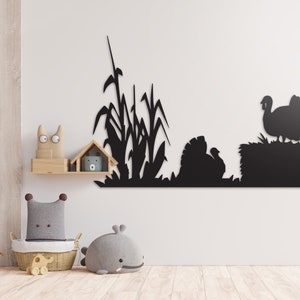 Op de afbeelding: Zwarte silhouet wanddecoratie met een paar kalkoenen en hoog gras. De kalkoenen staan op een hooiberg. De decoratie is perfect voor een boerderij of een rustieke stijl huis.