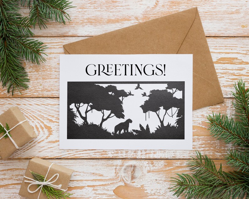 May include: A white card with the word "GREETINGS!" printed in black at the top. The card features a black silhouette of a jungle scene with trees, vines, and a leopard.