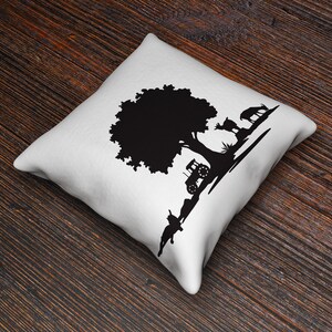 Peut inclure: Un coussin blanc avec un motif en silhouette noire d'un arbre, d'un tracteur et de cerfs.
