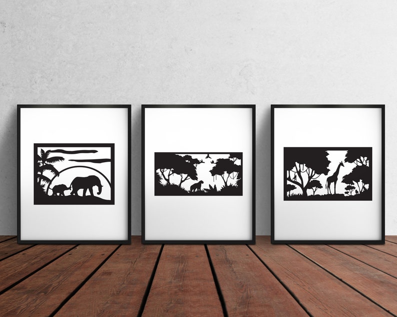 May include: Three black and white framed prints featuring silhouette images of African wildlife. The first print depicts an elephant and a baby elephant walking through a savanna landscape. The second print depicts a lion and a zebra walking through a savanna landscape. The third print depicts a giraffe standing in a savanna landscape.