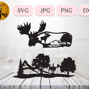 May include: Black silhouette of a moose with antlers standing in a forest scene with mountains and trees. The moose is looking to the right. The scene is cut out and ready to be used for crafting projects.