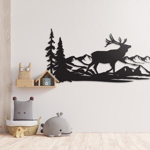 May include: Black metal wall art featuring a silhouette of an elk walking through a mountain landscape with trees.