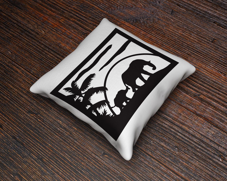 May include: White cushion with a black silhouette of two elephants walking through a jungle scene with palm trees. The elephants are walking towards a setting sun.