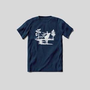 May include: A navy blue t-shirt with a white silhouette of an elk standing in a lake with trees on either side.