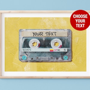 以下が含まれることがあります： 黄色の背景に、ビンテージスタイルのカセットテープ。テープには「YOUR TEXT」という文字がラベルに書かれています。テープは木製のフレームに入っています。