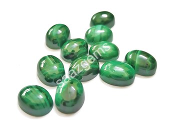 Puede incluir: Un conjunto de piedras preciosas verdes pulidas de forma ovalada. Las piedras tienen un acabado brillante y un aspecto veteado, con diferentes tonos de verde. La imagen incluye el texto "saazgems".