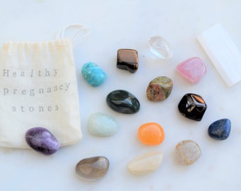 May include: A set of 14 tumbled stones in a white drawstring bag labeled "Healthy Pregnancy stones". The stones are various colors, including clear, pink, orange, green, blue, brown, and purple.