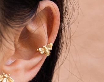 Boucle d'oreille manchette en forme d'abeille.