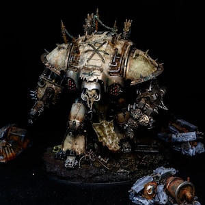Pode incluir: Modelo em miniatura detalhado de uma máquina de guerra, com um esquema de cores branco e bronze desgastado. O modelo apresenta detalhes intrincados, incluindo pontas, correntes e um rosto em forma de caveira. Está situado numa base escura e texturizada com detritos espalhados.