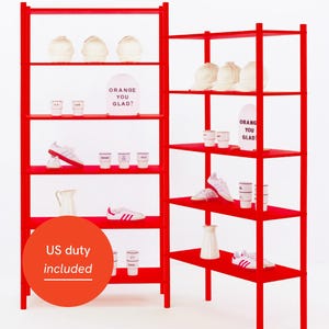 May include: A red shelving unit displaying various items. There are white hats, small cups, white and red trainers, and a white jug. A sign says "ORANGE YOU GLAD!" in a playful font.