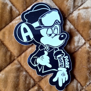 May include: Black and white sticker of a cartoon mouse wearing a ski mask and goggles. The mouse is wearing a jacket and has the words "Park Rats" written on its arm.