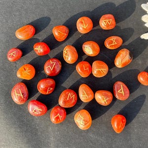 Hand-carved Carnelian Rune Set with engraved gold symbols for divination, meditation, Reiki, and chakra healing rituals